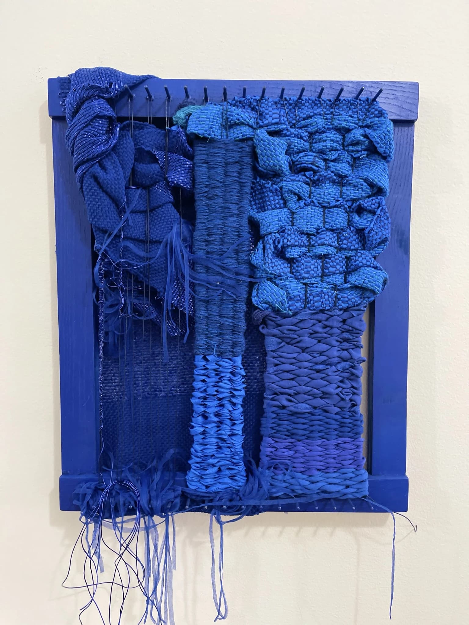 Fiber art wall hanging with intricate weave patterns