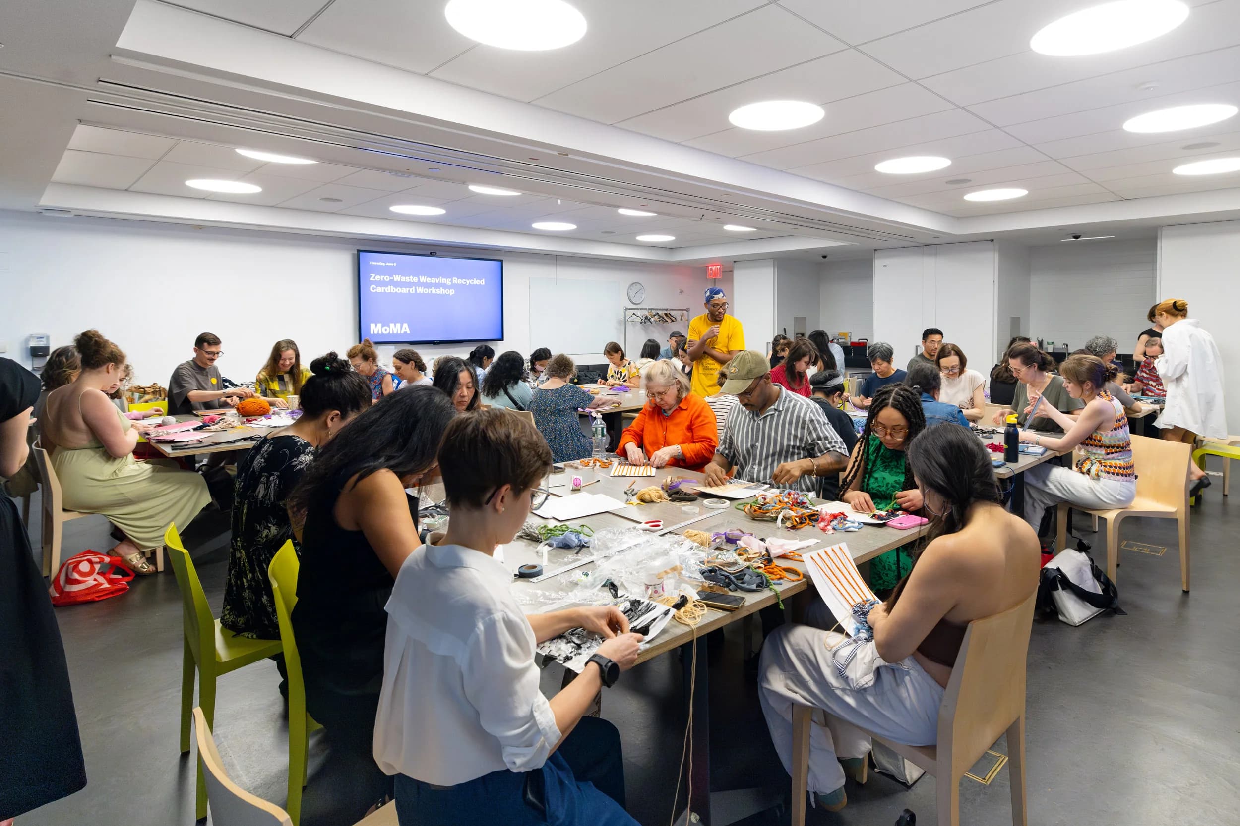 Participants collaborating on the community loom at MoMA